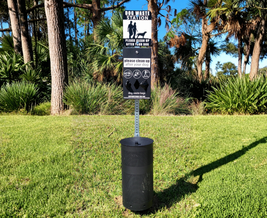 Dog waste station with bag dispenser and trash bin surrounded by greenery